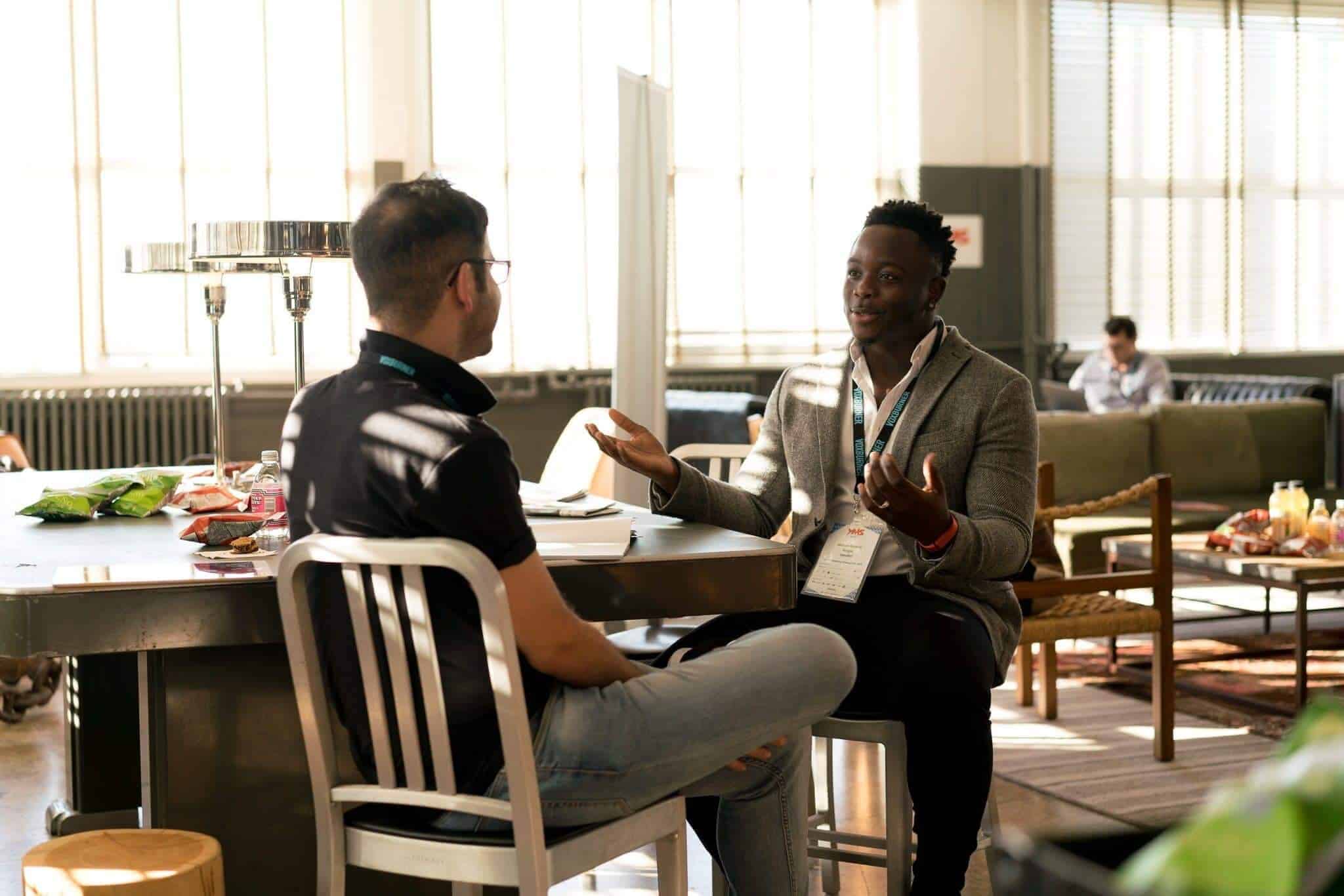 634324d52c7f3529aa2c19be_two-businessmen-having-conversation-at-table-Your-Guide-to-Running-An-Incredible-One-On-One-Meeting-1
